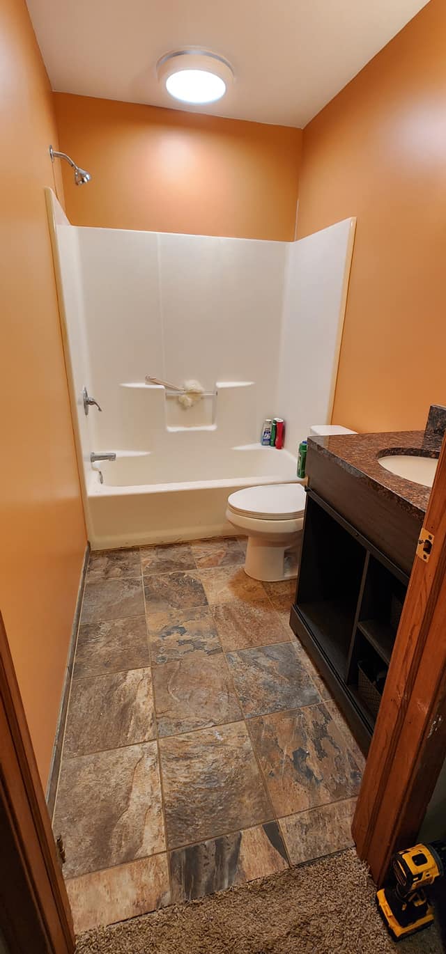 Bathroom painted in warm orange with dark vanity