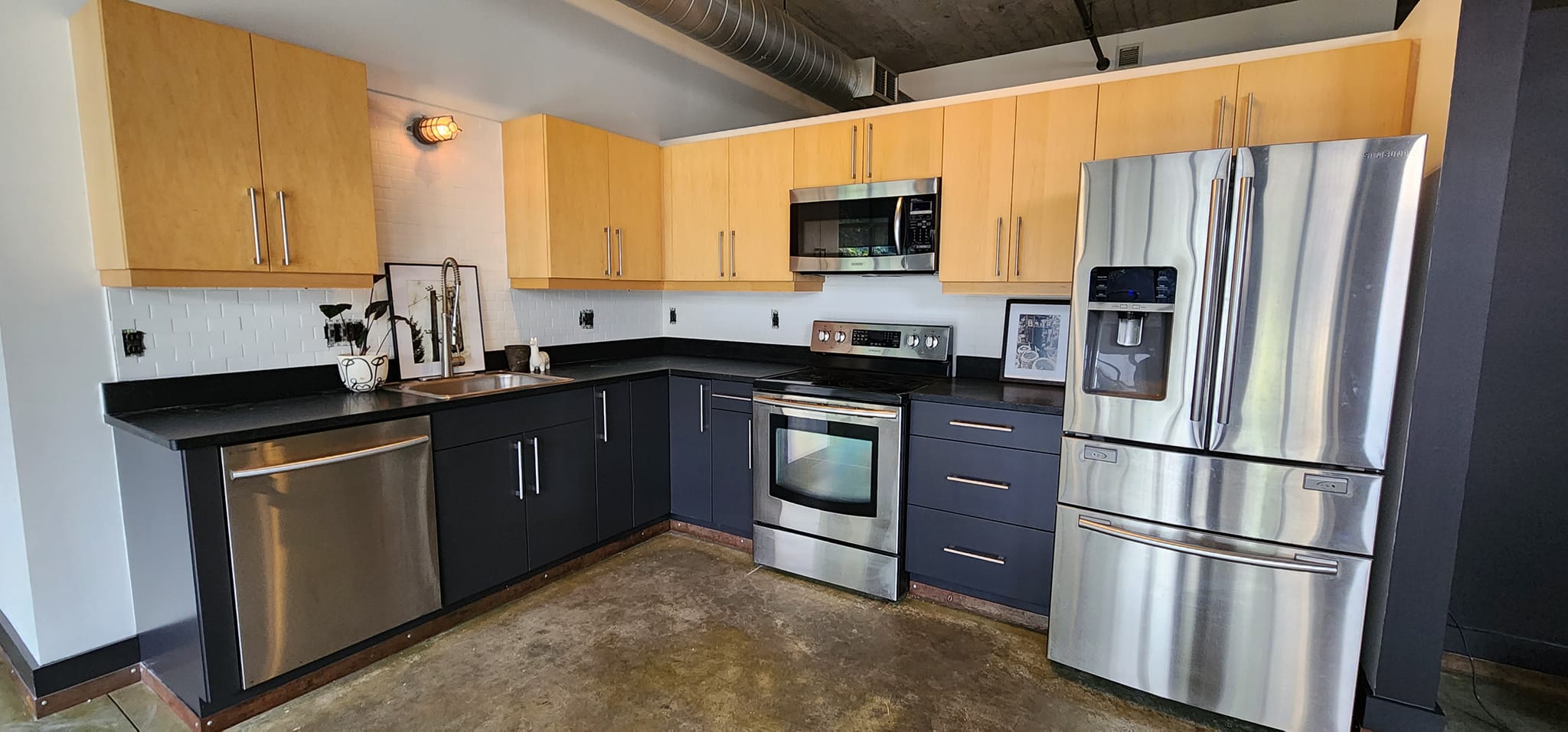 Kitchen with freshly painted navy lower cabinets